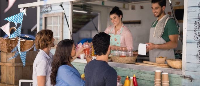 A couple selling food from a food truck