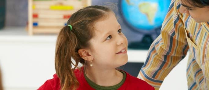 A teacher providing support to a child with autism in the classroom