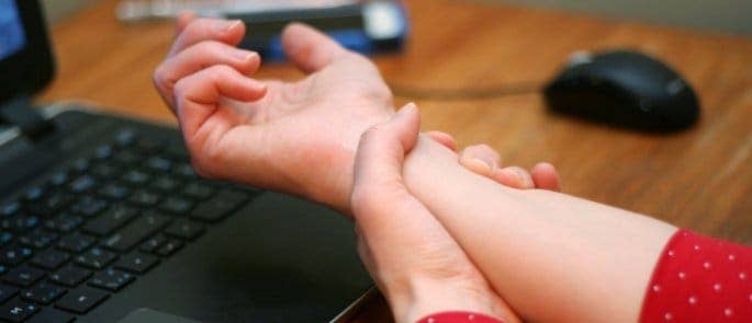 Employee with repetitive strain in her wrist after continuous use of an incorrectly set up workstation