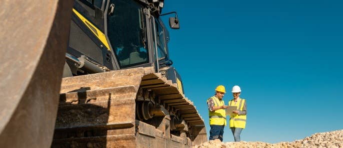 Banksman and driver discussing operation next to excavator