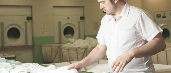 man working inside a care home laundry room