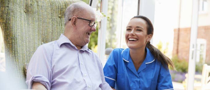 Carer and resident communicating in a care home