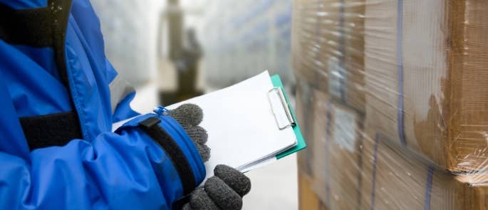 Person with clipboard carrying out checks of food products