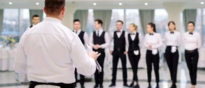 Chef stands infront of restaurant team talking about the menu