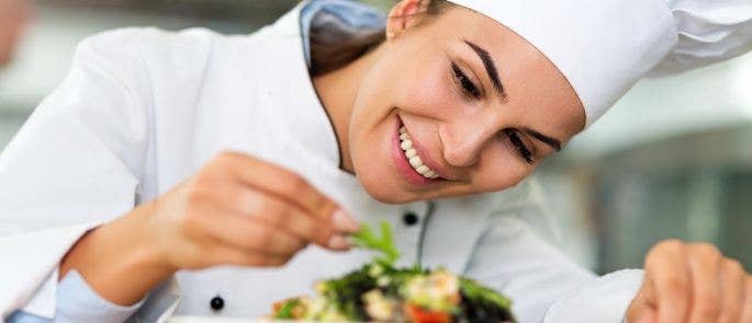 Female chef garnishing a dish