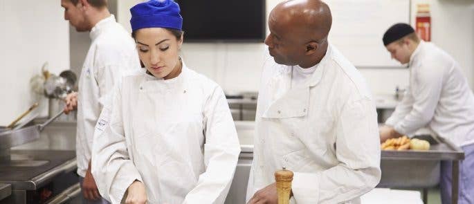 Head chef coaches young chef in kitchen