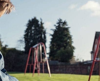 boy sits on bench in park