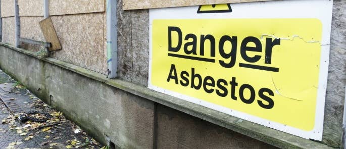 A sign at a building site saying 'Danger Asbestos'