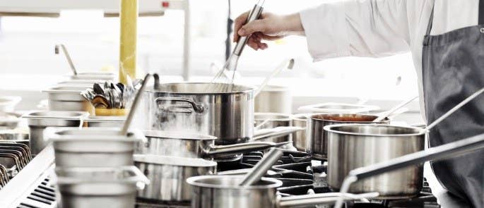 Chef cooking with lots of pans on a stove