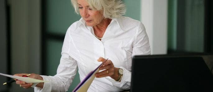 Employer reading safety data sheets at desk