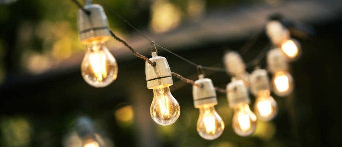 A string of hanging light bulbs at a BBQ event