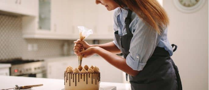 Woman decorating a cake for her food business