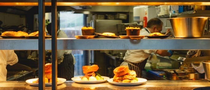 Three plates of sunday dinner sit on kitcehn pass ready to go to customer