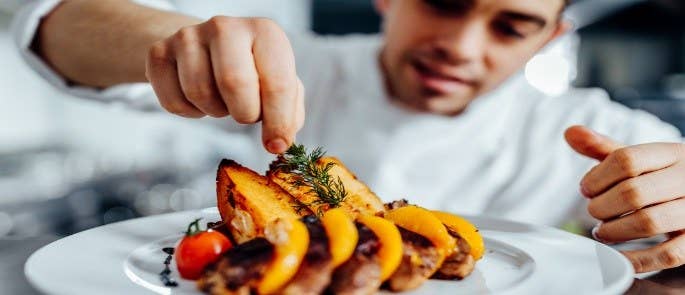 Chef preparing a plate of food in a restaurant kitchen