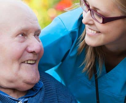 elderly man in a care home being looked after by a healthcare worker