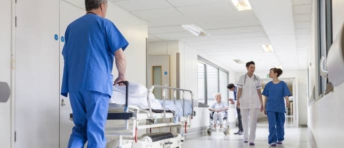 Hospital staff pushing a trolley and patient in a wheelchair