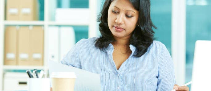 image of an indian lady doing a risk assessment in the office at a desk with a pen