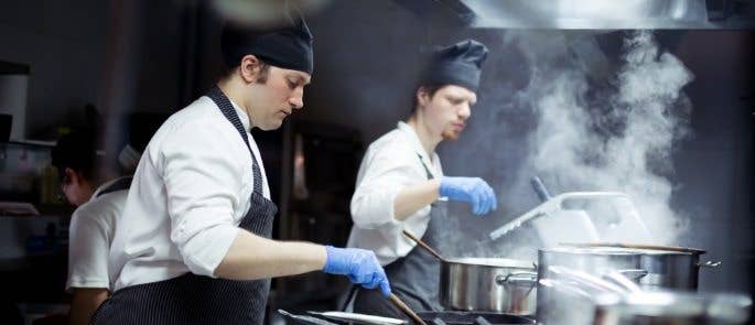 Two chefs working in a dark industrial kitchen