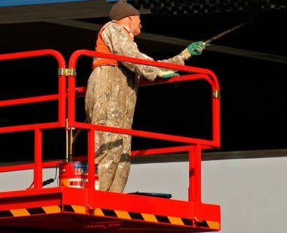 lone worker painting bridge at height