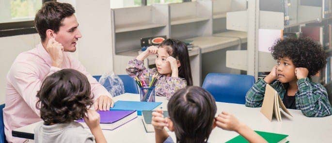 Teacher looking after young students in a classroom