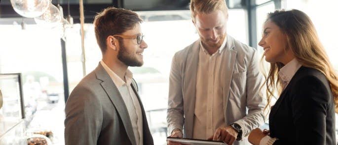 young man meets man and woman in restaurant for chef job interview