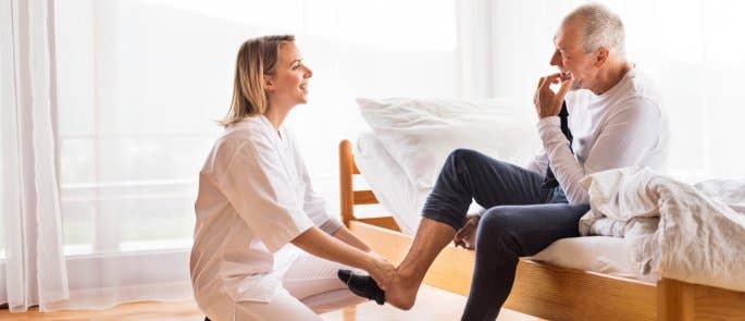 A health and social care worker assisting a patient