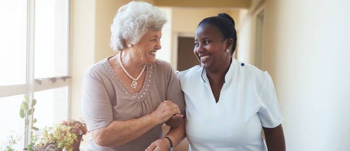 Nurse and patient walking in care home