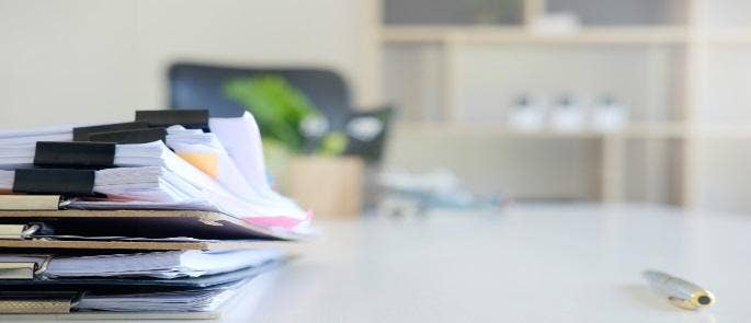 A pile of documents on a desk in an office