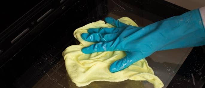 Person cleaning open oven door