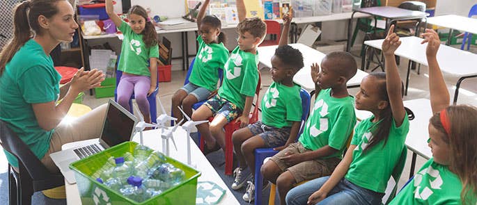 School teacher educating students about recycling