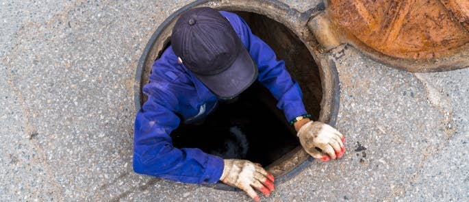 Lone worker entering a manhole