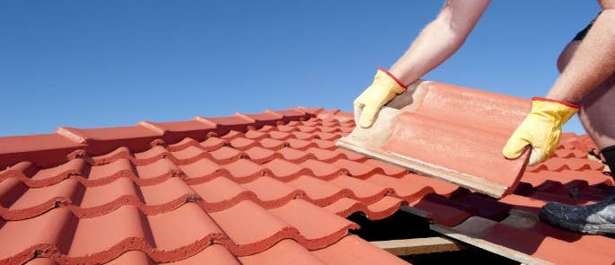 Worker on a roof laying tiles