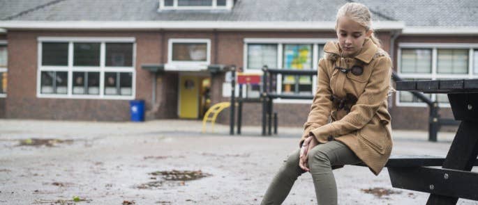 Teenage girl sat in the school playground