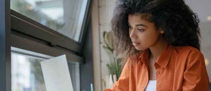 Young girl working on her laptop at college