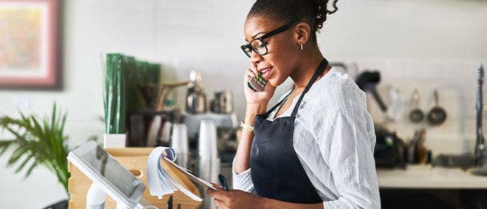 Woman taking phone orders in her hospitality business