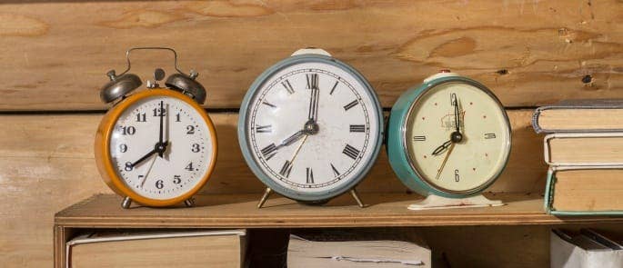 Three clocks on a shelf