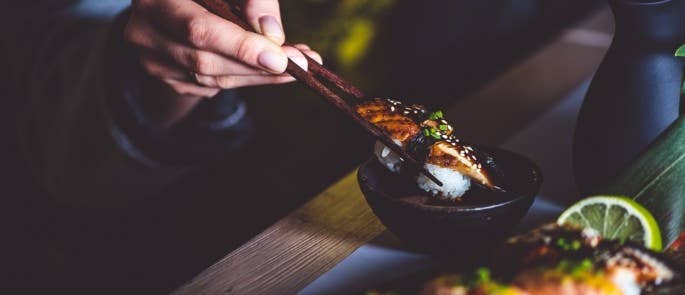 Woman eating freshly prepared unagi in a restaurant