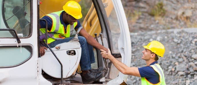 Banksman and vehicle driver shaking hands and talking