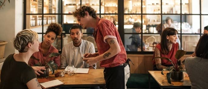 Waiter helping customers with allergen information