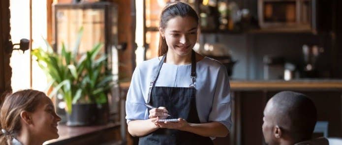 Waitress in a restaurant taking people's food orders