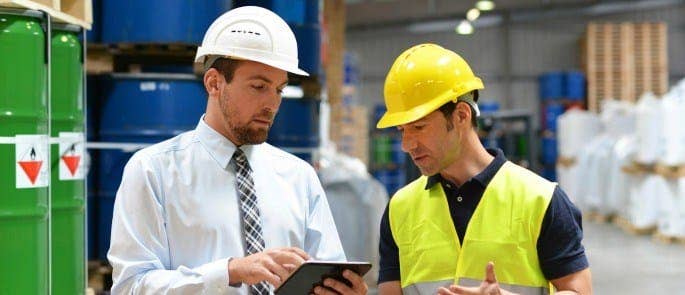 manager delivering feedback to employee in warehouse