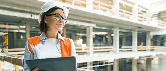 Woman at a construction site holding a clipboard