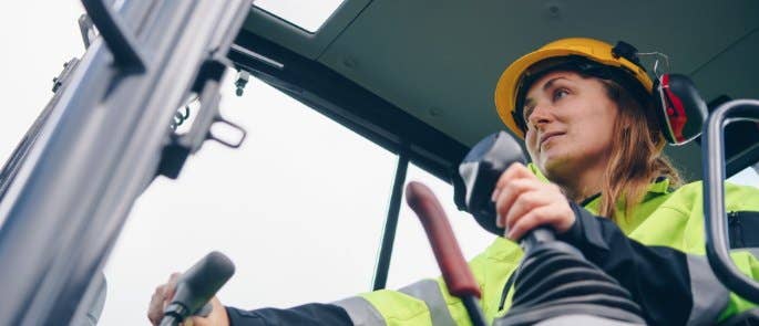 Worker driving vehicle on construction site