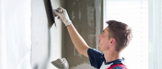 Worker plastering wall