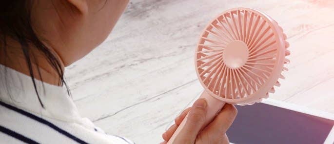 Worker using handheld fan