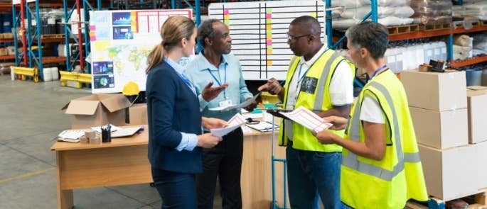 Workers in a warehouse discussing to dos