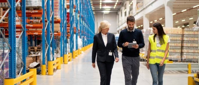 Workers walking in a warehouse talking