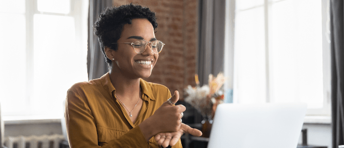 A happy individual doing sign language during their virtual interview process