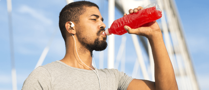 A person enjoying a caffeinated energy drink before a workout