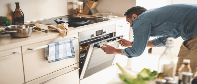 Man checking the temperature of his food in the oven